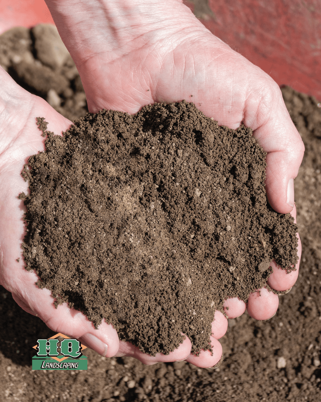 Hands holding a sample of screened topsoil from HQ Landscaping in Central Connecticut, showing fine texture and rich organic quality ideal for gardening and landscaping projects.
