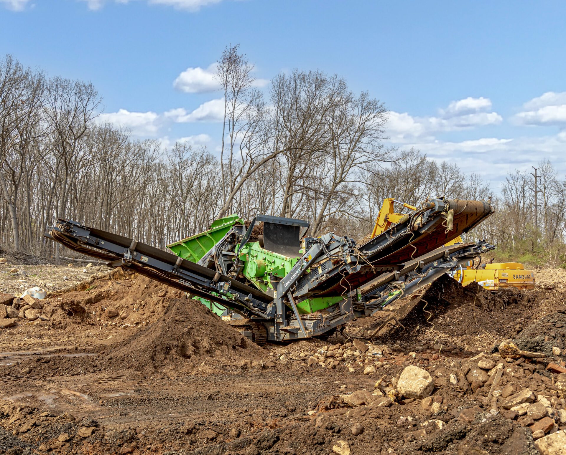 Screening machine processing topsoil at a Bristol, CT landscape supply yard — creating clean, high-quality screened topsoil for delivery and installation.